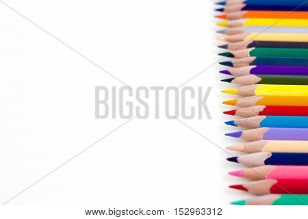 Colored pencils isolated on white background. Bright template with copyspace. Educational background.