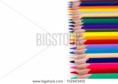 Colored pencils isolated on white background. Bright template with copyspace. Educational background.
