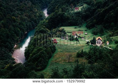 Camp farm in forest near river and mountains