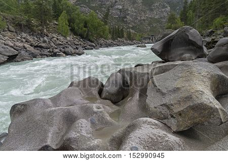 Bizarre stone on the shore of a mountain river. Rapids 