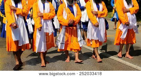 Sikh Soldiers Dressed In Traditional Orange Clothes March Barefoot During A Religious Celebration