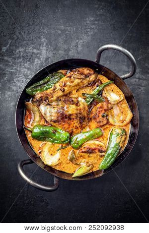 Traditional Thai kaeng massaman coconut chicken curry with jalapeno, poblano chili and sweet potatoes as top view in a traditional bowl 