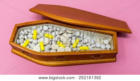 A Wooden Coffin Full Of Gray Round Pills