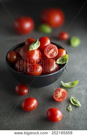Fresh Cherry Tomatoes With Basil Leaves. Concept For A Tasty And Healthy Meal.