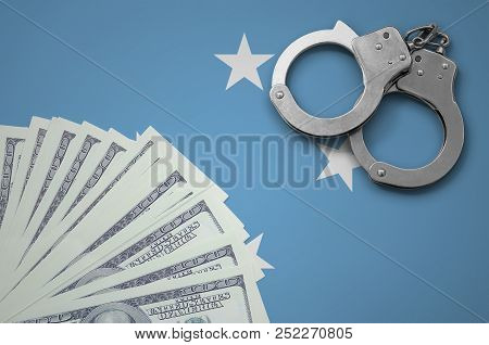Micronesia Flag  With Handcuffs And A Bundle Of Dollars. The Concept Of Illegal Banking Operations I