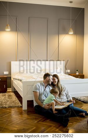Parents Reading Book To Little Boy And Have Fun On The Floot In The Room
