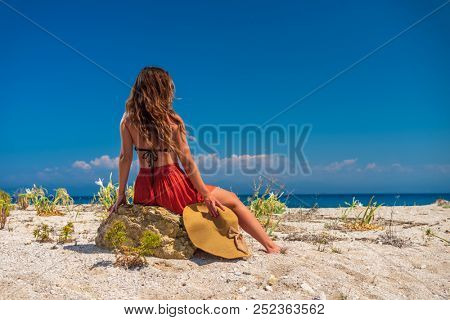 Woman in red outfit posing at the beach in Greece