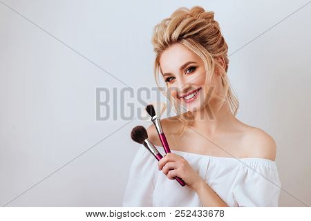 Fashion Glamour Portrait Of Happy Smiling Blonde Woman Long Wavy Hair Style Holding Brush Over Light