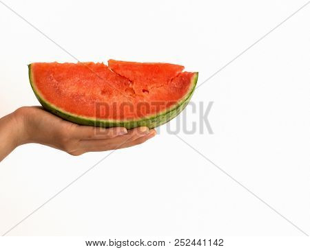 Hand Holding Slice Of Watermelon With A Blurred Background