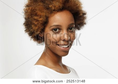 Indoor Closeup Of African American Female Standing Isolated Against Grey Background Wearing Golden E
