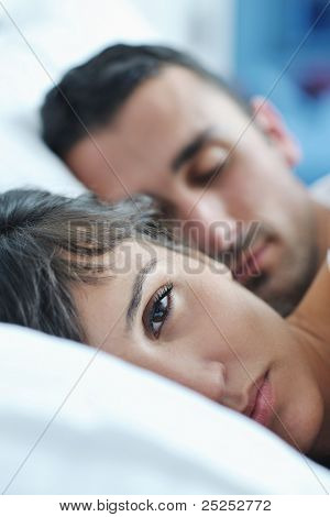 happy young healthy people  couple have good time in their bedroom make love and sleep