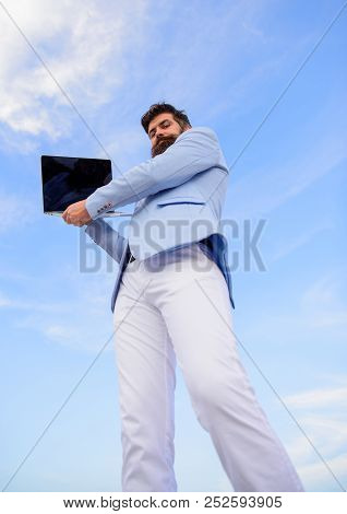 Man Well Groomed Bearded Hipster Holds Laptop Blue Sky Background. Guy Formal Suit Modern Technology