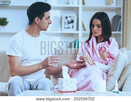 Careful Man Treat With Pills. Bad Feeling Woman. Disease. Young Man Help Treat Girlfriend. Virus At 