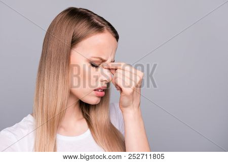Close Up Portrait Of Exhausted Young Woman, Holding Her Nose Bridge With Closed Eyes, She Is Tired A