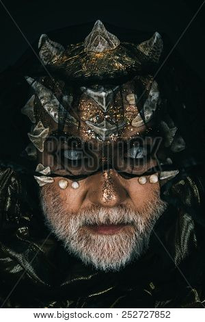 Demon With Golden Skin, Thorns On Faceand Grey Beard Giding Under Dark Veil. Portrait Of Man With Fi