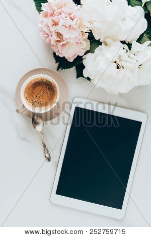 Top View Of Cup With Espresso Coffee, Hortensia Flowers And Digital Tablet With Blank Screen On Marb