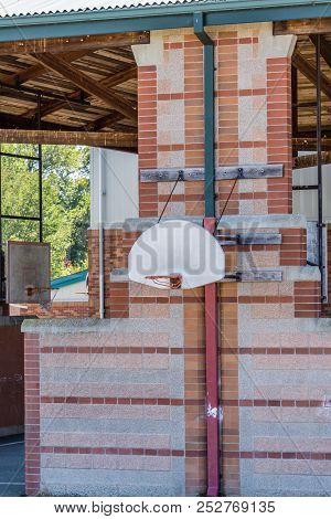 A View Of A Basketball Hoop At A School.