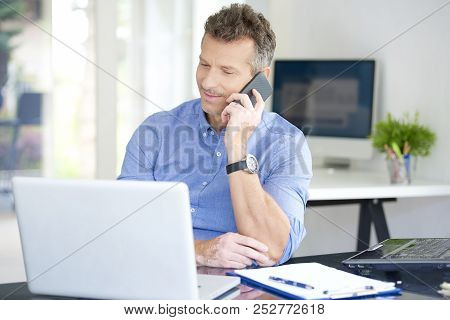 Businessman With Mobile Phone And Notebook In The Office