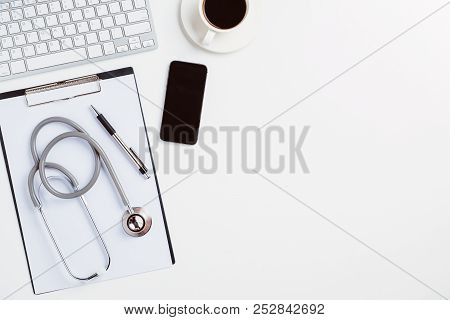Medical Desk With Stethoscope,heart,pen,laptop,mouse And X-ray Film On White Desk.top View With Copy