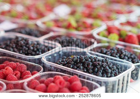 Assortement Of Organic Berries In Boxes At Market. Raspeberries, Blackberries And Raspberries.