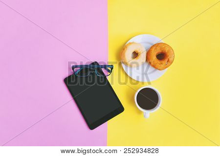 Modern Home Office Workplace At Coffee Time, A Cup Of Coffee, Donuts, Eye Glasses And Tablet On Yell