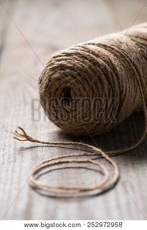 Selective Focus Of Untangled Beige String On Wooden Background