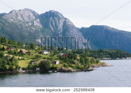 View of Jondal Commune and Hardangerfjord Fjord, Norway. Summer landscape with a Scandinavian village. Sunny weather