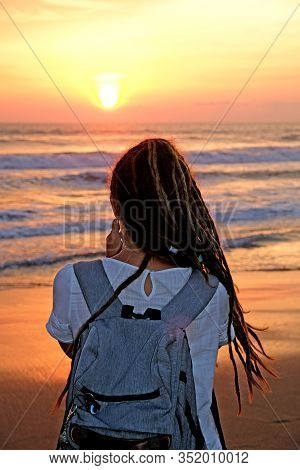 A Close Up Of A Girl With Dreadlocks Looking At The Beautiful Ocean Sunset