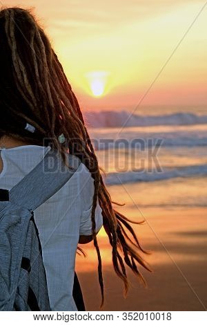 A Close Up Of A Girl With Dreadlocks Looking At The Beautiful Ocean Sunset