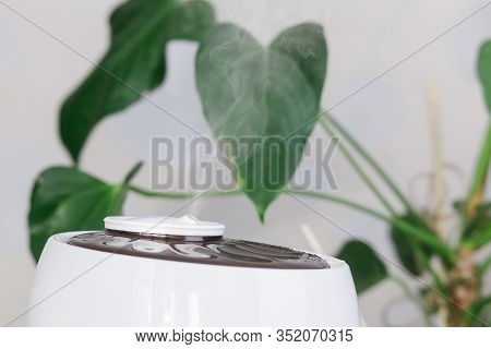 Close Up Photo Of White Air Humidifier Spreading Steam. Humidification Of Dry Air. Selective Focus O