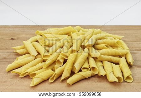 Maccheroni Al Pettine On Wooden Background. Raw Italian Pasta