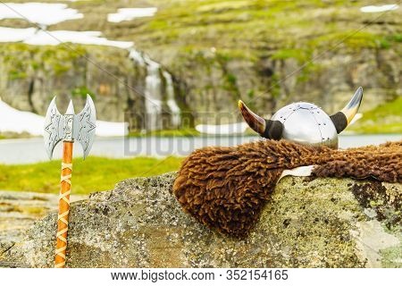 Viking Helmet With Axe On Lake Shore In Norway. Tourism And Traveling Concept