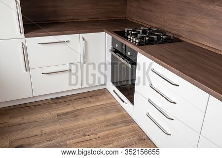 A Modern Gas Cooker With Ceramic Hob, Electric Oven And A Dark Brown L-shaped Wooden Kitchen Ready F