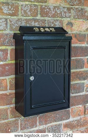 Vintage Black Post Box Or Letterbox On A Brick Wall In England, Uk