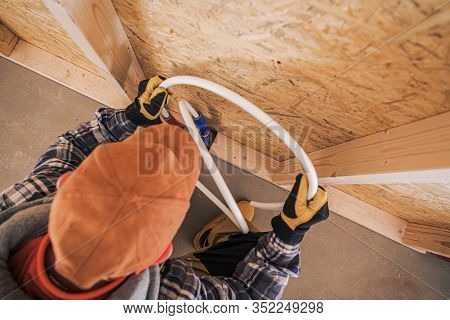 Construction Plumbing Contractor Installing Cold And Hot Water Line In Newly Constructed Bathroom. I