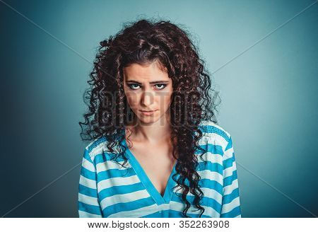 Upset. Closeup Portrait Sad Grumpy Culry Brunette Woman Looking At You Camera Isolated On Blue Wall 