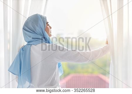 Rear View Beautiful Asian Muslim Woman Wearing White Sleepwear, Stretching Her Arms After Getting Up