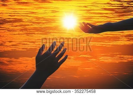 Giving A Helping Hand On The Background Of The Sunset.
