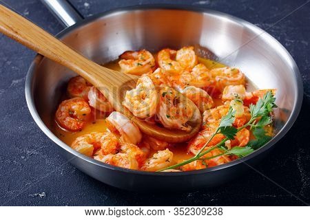 Seafood Dish Shrimp Scampi With Garlic Butter Sauce With Parsley, On A Skillet On Concrete Backgroun