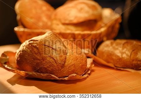 Different Buns Of Fresh Bread On A Brown Vintage Background. Freshly Baked Wheat Bread, Still Life W