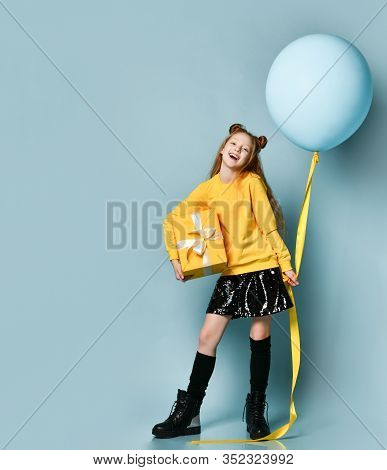 Ginger Teen Child In Yellow Sweatshirt, Black Skirt, Knee-highs, Boots. Smiling, Holding Balloon And