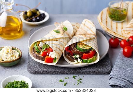 Wrap Sandwich With Grilled Vegetables And Feta Cheese On A Plate. Grey Background. Close Up.