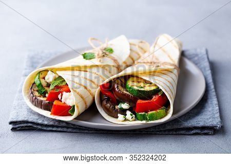 Wrap Sandwich With Grilled Vegetables And Feta Cheese On A Plate. Grey Background. Close Up.