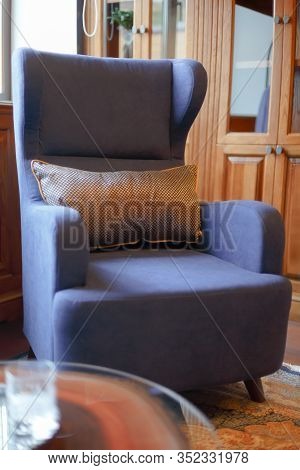 Blue Armchair In A Classic Office. Decor Element. On The Armchair Lies A Golden Pillow.