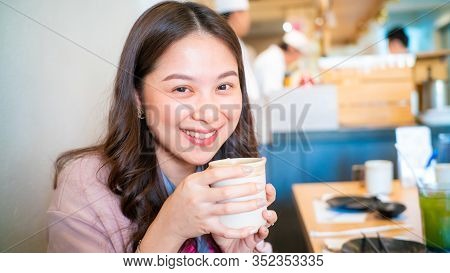 Beautiful Asian Women Hold Hot Matcha Genmai Tea Drink In Japanese Restaurant
