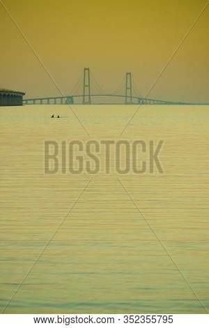 The Bridge Across The Great Belt - The Storebaelt Bridge In Denmark. Two Canoes On Water Surface. Su