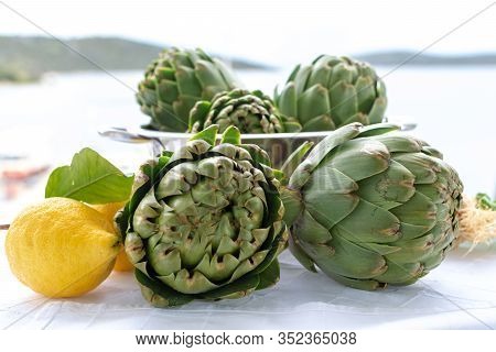 Cooking Dinner With Fresh Green Artichokes Heads, Tasty Vegetarian Food, On Open Kitchen With Sea Vi