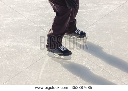 Man Skating On Open Streen Skating Rink. Legs Of A Skater. Winter Leisure And Sports Concept. Active