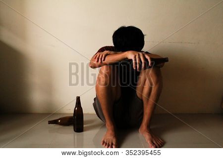 Drunken Man With Beer Bottle Are Having Stress In Life And Sitting Alone In A Empty Room, Sad ,lonel