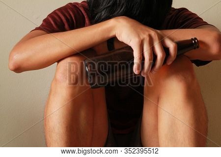 Drunken Man With Beer Bottle Are Having Stress In Life And Sitting Alone In A Empty Room, Sad ,lonel